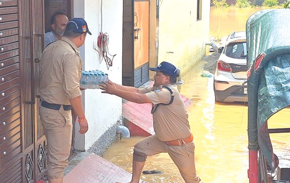बाढ़ प्रभावित क्षेत्रों में पुलिस ने घर-घर जाकर बांटा पानी और बिस्कुट